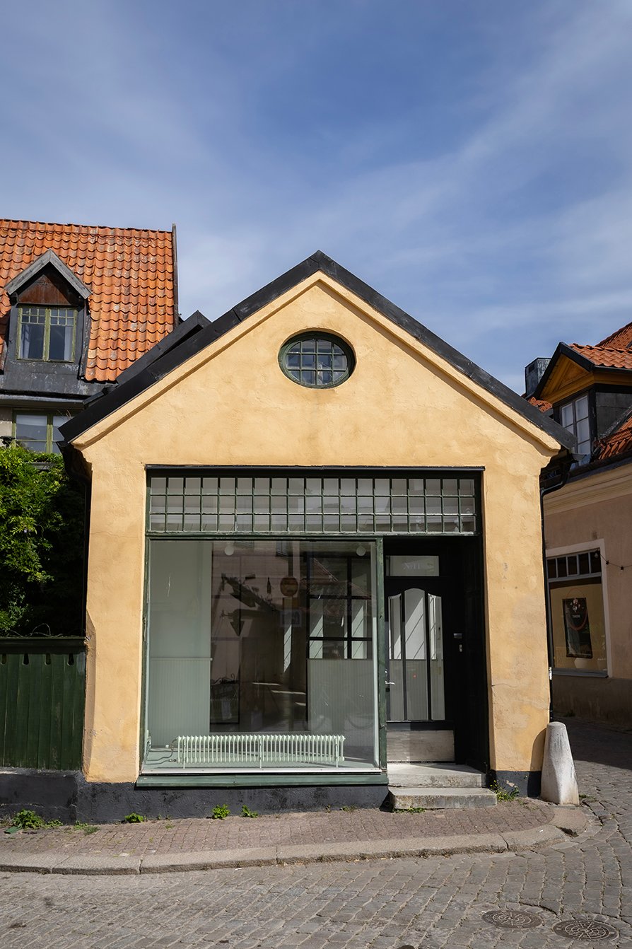 Häggska huset på Södra Kyrkogatan 11 – gul fasad med gröna fönster och entré mot gatan