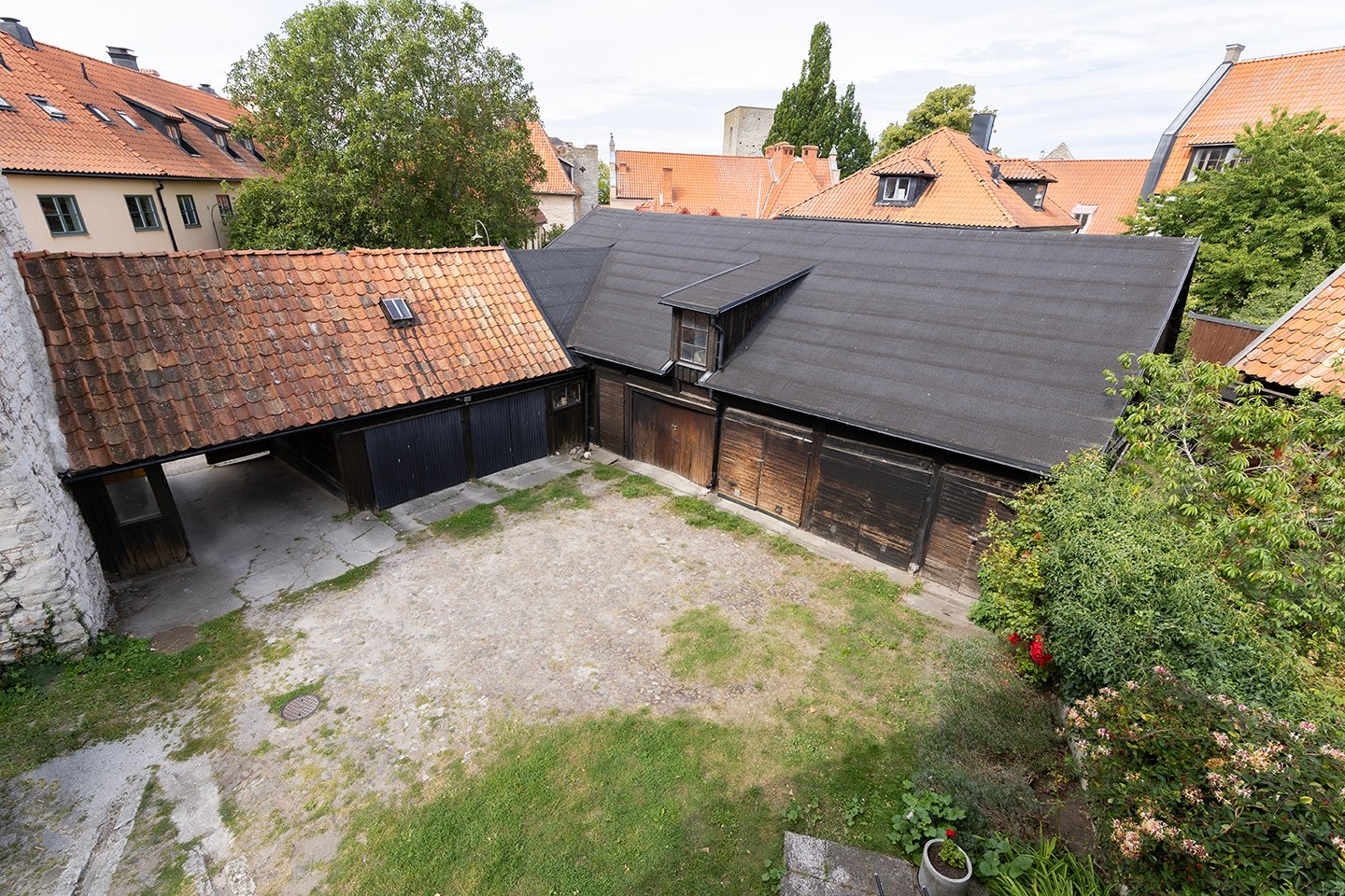 Stor innergård med gräsyta och gamla trälängor